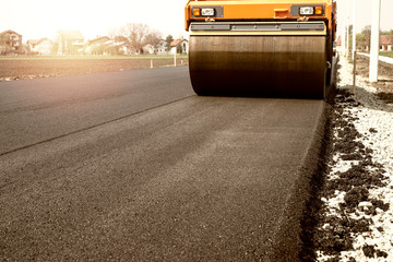 Road machine working on new asphalt. Road construction.