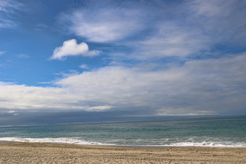 Fototapeta na wymiar Calm ocean under cloudy blues kies