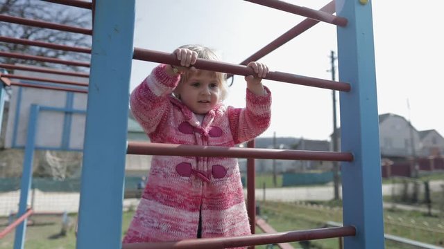Funny cute girl is playing. Joyous female child having fun on playground