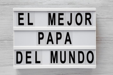 Fototapeta premium 'El Mejor Papa Del Mundo' words on lightbox over white wooden background, top view. Overhead, from above, flat lay. Father's day.
