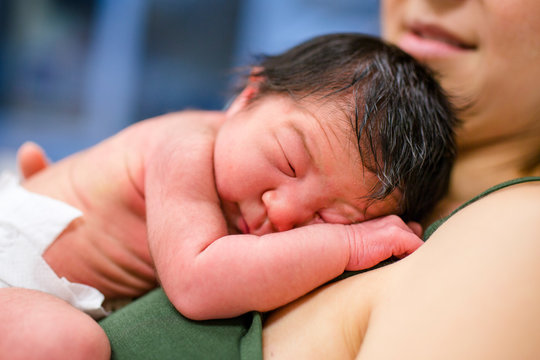 Mother cradles newborn daughter