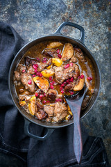 Traditional Iranian khoresh beh stew with chunks of lamb, quinces and pomegranate as top view in a...