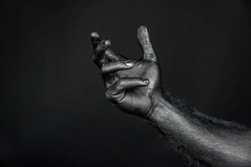 outstretched hand completely in black paint