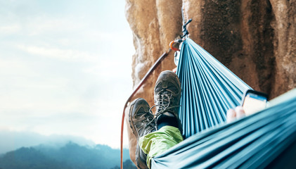 Climber resting in hammock on the vertical cliff wall
