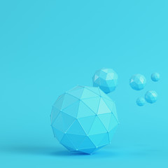 Low poly abstract spheres on bright blue background in pastel colors