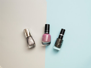 Beauty and care concept. Nail polish bottles different colors. Nail polish blue background. Manicure salon. Durability and quality of nail polish coating. Gel polish modern technology. Fashion trend