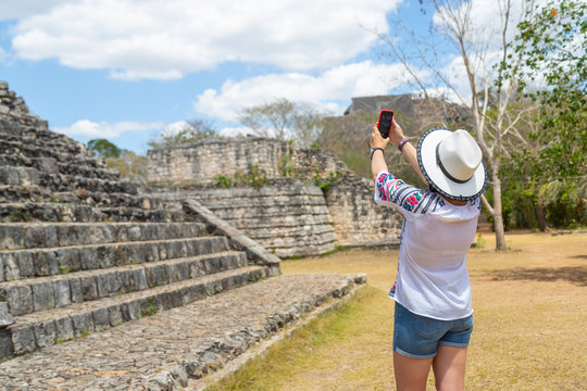 Tourist in the archaeological area takes pictures on the smartphone. Ancient Maya city of Ek Balam. Archaeological zone of the ancient Mayan civilization, Yucatan, Mexico