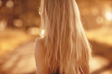blonde long hair nature summer / happy adult girl with developing in the wind long blonde hair in...