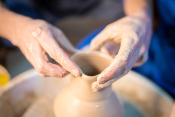 Working process of man's work at potters wheel in art studio. Unknown craftsman creates jug. Focus...