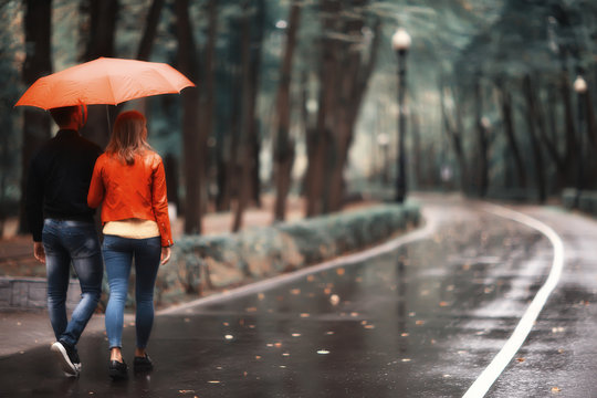 Rain In The Autumn Park / Young 25 Years Old Couple Man And Woman Walk Under An Umbrella In Wet Rainy Weather, Walk October Lovers