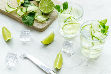 Obraz premium cold water with ice, spinach, cucumber and lime juice for summer healthy drink on white background