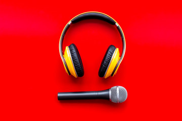 podcast record with microphone and headphones on red background top view