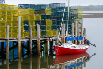 Fototapeta na wymiar Lobster Traps on Wharf with Boat at Anchor