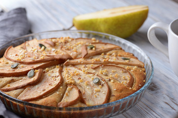 gorgeous pie with pears in a glass container on wooden background