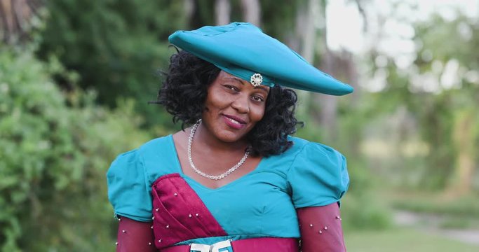 4K close-up portrait of pretty black Herero woman in Traditional Dress looking at the camera 