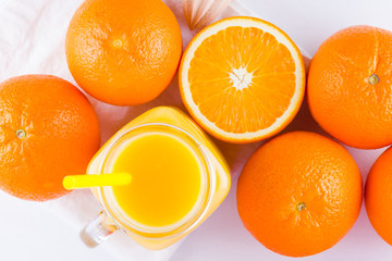 Orange fruits and juice on white background. Citrus fruit for making juice with manual juicer. Oranges on white napkin. Mason jar with orange juice