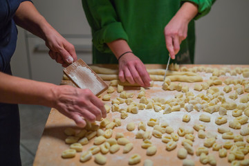 Cooks hands preparing raw pumpkin gnocchi 