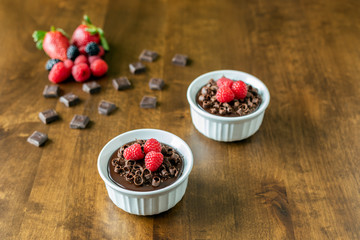 A decadent Chocolate Mousse Cake with chocolate ganache and topped with Raspberries, Blackberries and chocolate curls in a ramekin