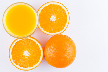 Orange fruits with juice, concept. Orange juice and halves of oranges on white background. Citrus for making juice. Whole and squeezed oranges and glass of juice