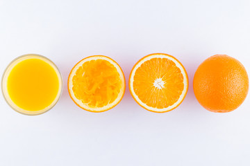 Orange fruits with juice, concept. Orange juice and halves of oranges on white background. Citrus for making juice. Whole and squeezed oranges and glass of juice