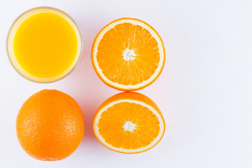 Naklejka na ściany i meble Orange fruits with juice, concept. Orange juice and halves of oranges on white background. Citrus for making juice. Whole and squeezed oranges and glass of juice