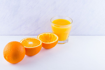 Orange fruits with juice, concept. Orange juice and halves of oranges on white background. Citrus...