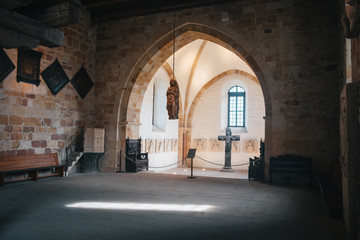 Fototapeta na wymiar Catholic church interior with medieval walls and arch designed construction. Holy cross and gothic architecture