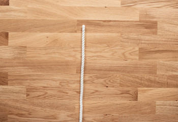 The letter I formed with white rope on a wooden table