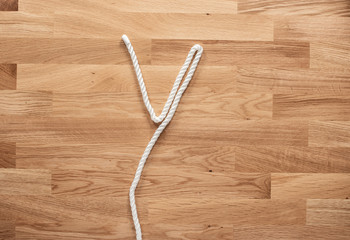 The letter Y formed with white rope on a wooden table