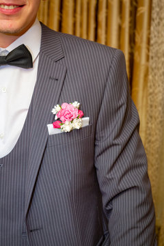 The Groom In A Gray Pinstripe Suit, White Shirt With Black Bow Tie, With Flowers In His Jacket Pocket.