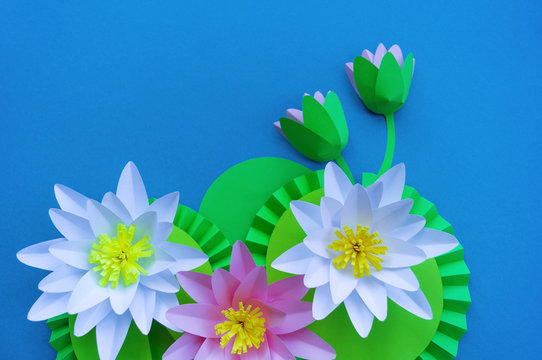 Waterlily flower made of paper. Blue background. Origami hobby. Gentle petal.