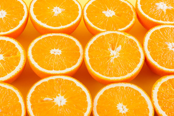 Cut halves of juicy orange on yellow background. Orange fruit, citrus minimal concept. Creative summer food minimalistic background. Top view, flat lay