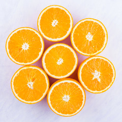 Sliced oranges fruit on white background. Citrus for making juice. Halved oranges creatively stacked on table. Background of oranges. Top view