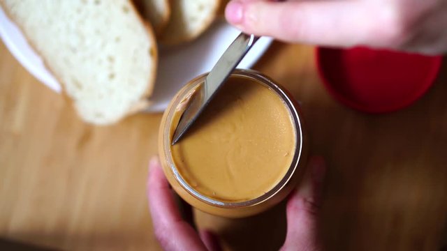 Woman opens a jar of peanut butter