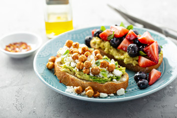 Healthy avocado toast duo with chickpeas and fruit