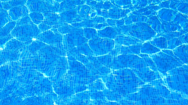 Sunlight reflecting on the surface of a cool clear swimming pool making abstract shapes of light. Tiled pattern on the bottom of the pool. Relaxing and refreshing blue water background.