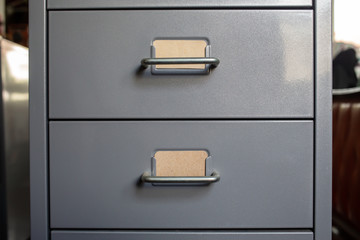 Filing cabinet with closed drawer, 2 brown cards for write letter, Grey silver metal colour,...