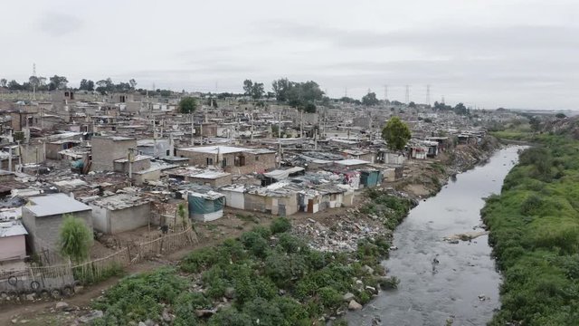 4K close-up aerial panning view of slums or squatter camp along the Jukskei river in the Alexandra township, South Africa 