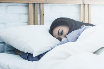 Fototapeta na wymiar Asian woman sleep on white pillow on bed in bedroom in holiday.happy relax time.color tone