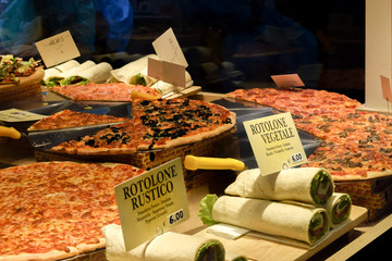 Italian food. Pizzeria window display with Pizza, Pasta, Rolls in Venice Italy restaurant.