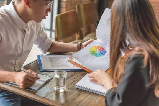 Man and woman working together with financial document