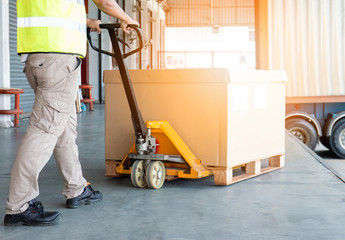 Workers Using Hand Pallet Jack Unloading Package Boxes into Cargo Container. Delivery Shipment...