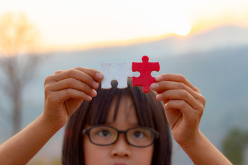 Little child holding piece of blank jigsaw puzzle