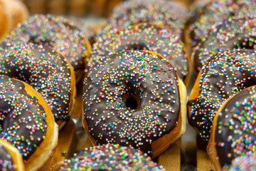 Fototapeta na wymiar Pastries concept. Donuts with chocolate glaze with sprinkles, background, closeup