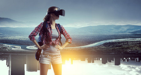 Travelling female tourist with backpack and VR helmet