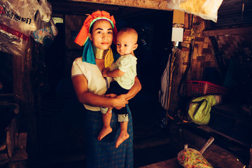 Fototapeta na wymiar Long Neck Woman is sitting with her child. Tribal village Northern Thailand.