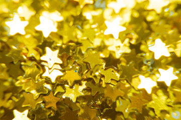 Gold glitter stars texture. Festive sparkling sequins background. Wpaper for Valentine, New Year or Christmas Holidays.