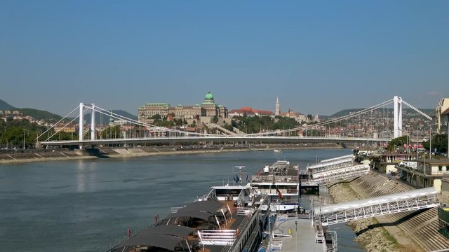 Buda Castle and The Elisabeth Bridge viewed across The Danube with Cruise Ships moored in the foreground. LOCKED OFF shot from The Liberty Bridge on a sunny day, Budapest, Hungary.
