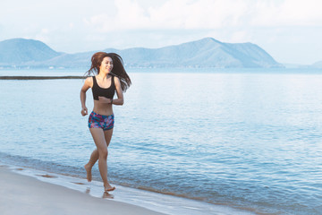 Fototapeta premium Middle-aged women who is running on the beach with clean white sand. good health and happiness concept.