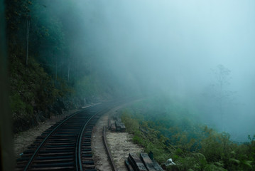 Fototapeta na wymiar Railroad with a turn leaving in the fog, Asia, mountains